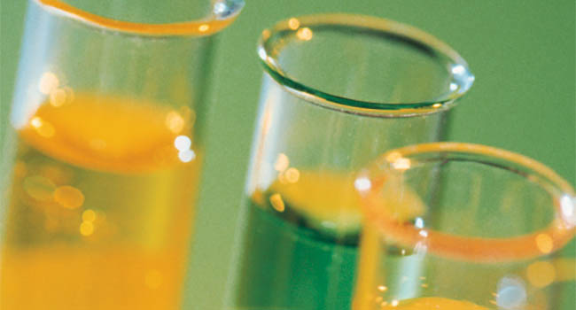 Test tubes filled with green and yellow liquids.